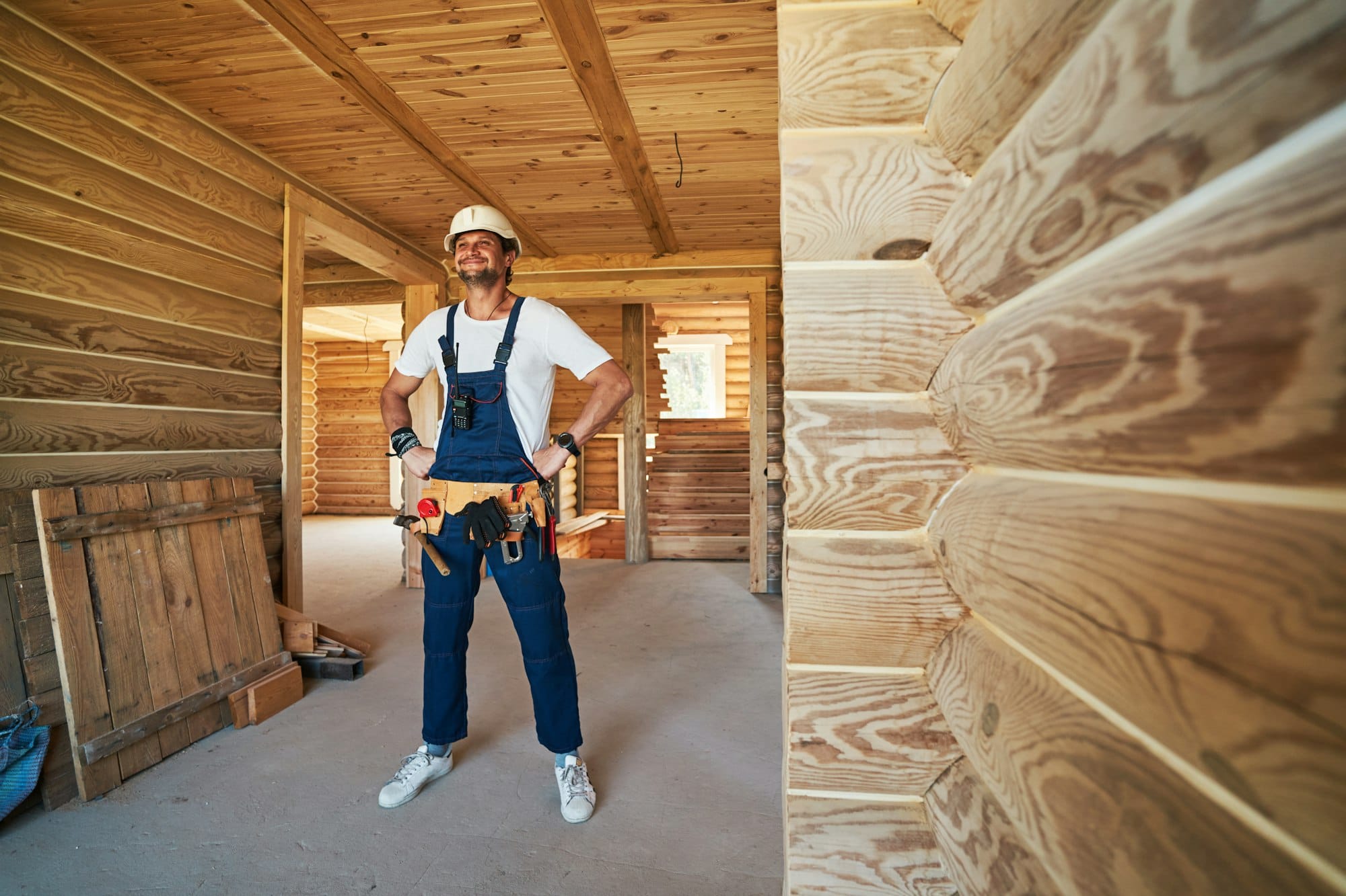 Satisfied construction worker with tool belt looking ahead
