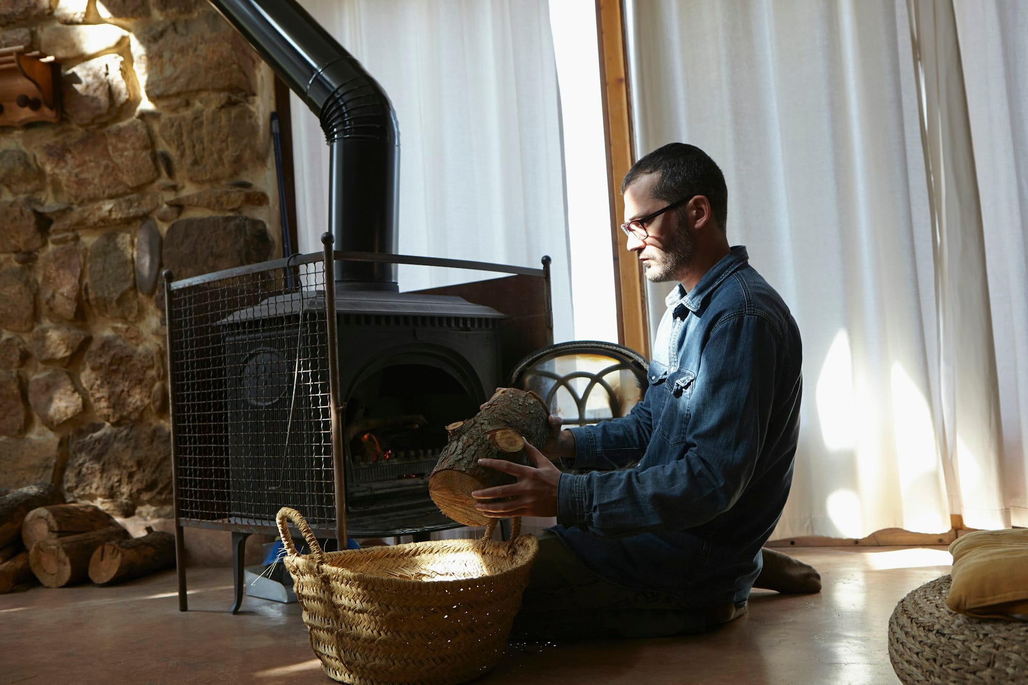 Mid adult man preparing log fire